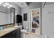 Bathroom with granite countertop, dark vanity, and view of a screened patio at 2102 Golf Manor Blvd, Valrico, FL 33596