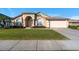 Tan house with arched entryway, American flag, and landscaped yard at 2102 Golf Manor Blvd, Valrico, FL 33596