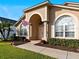 House exterior with arched entryway, columns, and American flag at 2102 Golf Manor Blvd, Valrico, FL 33596