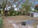 Large backyard with fire pit, shed, and mature trees at 2104 W Okaloosa Ave, Tampa, FL 33604