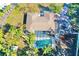 An aerial view showcasing a home, pool, and surrounding trees at 2142 Hickory Gate W Dr, Dunedin, FL 34698