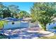 Property boasts a large driveway and mature trees at 2142 Hickory Gate W Dr, Dunedin, FL 34698