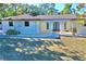 White single-story home with arched entryway and landscaping at 2142 Hickory Gate W Dr, Dunedin, FL 34698