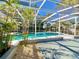 Spacious screened pool area with tropical landscaping at 2142 Hickory Gate W Dr, Dunedin, FL 34698