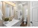 Bathroom with toilet, white vanity, gold fixtures, and a large mirror at 2860 4Th S Ave, St Petersburg, FL 33712