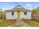 Front view of a charming bungalow with a yellow door and small front yard at 2860 4Th S Ave, St Petersburg, FL 33712