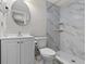 Clean bathroom with white vanity, marble shower, and toilet at 3148 Domino Dr, Holiday, FL 34691