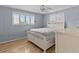 Bedroom with light blue walls, wood flooring, and a white bed frame at 3148 Domino Dr, Holiday, FL 34691