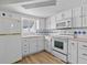 White kitchen with stainless steel appliances and blue tile at 3148 Domino Dr, Holiday, FL 34691