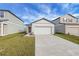 New construction home with a two-car garage and a well-manicured lawn at 35605 Buttonweed Trl, Zephyrhills, FL 33541