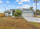 Single-story home with a two-car garage and a well-maintained lawn at 4994 Klosterman Oaks Blvd, Palm Harbor, FL 34683