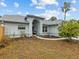 Front yard view of the house with walkway and landscaping at 4994 Klosterman Oaks Blvd, Palm Harbor, FL 34683