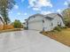 Front view of the house with a driveway and landscaping at 4994 Klosterman Oaks Blvd, Palm Harbor, FL 34683