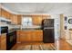 Kitchen with wood cabinets, black appliances, and a view of the backyard at 5149 Jo St, Zephyrhills, FL 33542