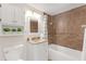 Clean bathroom with brown tile, white vanity, and bathtub at 5161 Rena N St, St Petersburg, FL 33709