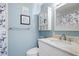 Light blue bathroom with white vanity, marble countertop, and shower at 5750 80Th St N # B106, St Petersburg, FL 33709