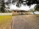 Tan one-story house with a gravel driveway and small porch at 5805 34Th S Ave, Tampa, FL 33619