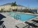 Community pool with lounge chairs and surrounding buildings at 6769 Breezy Palm Dr, Riverview, FL 33578