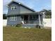 Gray two-story house with a porch, landscaped lawn, and white fence at 7336 Orchard Dr, Wesley Chapel, FL 33545