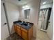 Updated bathroom with dark countertop, light wood cabinets, and shower at 7533 Pitch Pine Cir # 18, Tampa, FL 33617