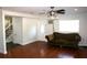 Living room with hardwood floors, a sofa, and access to the hallway at 8006 N Rome Ave, Tampa, FL 33604