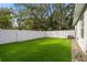 Landscaped backyard with artificial turf and white fence at 808 W Hollywood St, Tampa, FL 33604