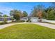 Curved driveway, gray house with a two-car garage and white fence at 808 W Hollywood St, Tampa, FL 33604