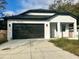 Modern white house with black garage door and driveway at 8206 N Marks St, Tampa, FL 33604