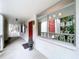 Condo building exterior showcasing a walkway with a red door and lush landscaping at 1012 Pearce Dr # 211, Clearwater, FL 33764