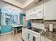 White cabinets, granite countertops, and teal accents in this galley kitchen at 1012 Pearce Dr # 211, Clearwater, FL 33764