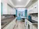 Bright kitchen with white cabinets, granite counters, and teal walls at 1012 Pearce Dr # 211, Clearwater, FL 33764