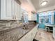 Modern kitchen featuring white cabinets, granite countertops, and a stylish backsplash at 1012 Pearce Dr # 211, Clearwater, FL 33764