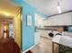 Bright kitchen with white cabinets, granite counters, and teal walls at 1012 Pearce Dr # 211, Clearwater, FL 33764