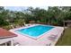 Community pool with lounge chairs and patio tables at 1012 Pearce Dr # 211, Clearwater, FL 33764