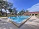 Relaxing pool area with shaded seating and a clubhouse at 1012 Pearce Dr # 211, Clearwater, FL 33764