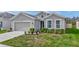 One-story home with gray siding, two-car garage, and neatly landscaped front yard at 10399 Gliding Eagle Way, Land O Lakes, FL 34638