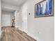 Light and spacious hallway with wood-look floors and an elegant wall art piece at 10399 Gliding Eagle Way, Land O Lakes, FL 34638