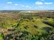 Aerial view of expansive land surrounded by luscious trees with ponds at 10601 Paul S Buchman, Plant City, FL 33565