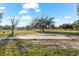 Vast land with scattered trees under a bright sky, featuring a sturdy concrete foundation at 10601 Paul S Buchman, Plant City, FL 33565