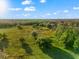 Sprawling aerial view of grassy land with scattered trees under a clear blue sky and white clouds at 10601 Paul S Buchman, Plant City, FL 33565