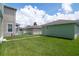 Green storage shed in a backyard with a grassy area at 11125 Winthrop Lake Dr, Riverview, FL 33578