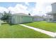 Green storage shed in a backyard with a grassy area at 11125 Winthrop Lake Dr, Riverview, FL 33578