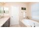 Bathroom with a garden tub, double vanity, and a window with blinds at 11125 Winthrop Lake Dr, Riverview, FL 33578