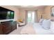 Relaxing bedroom with a king-size bed, comfy chair, large TV, and balcony access at 11125 Winthrop Lake Dr, Riverview, FL 33578