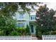 Two-story light green house with white picket fence and landscaping at 11125 Winthrop Lake Dr, Riverview, FL 33578