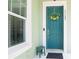 Teal front door with a spring floral wreath and small green stool at 11125 Winthrop Lake Dr, Riverview, FL 33578