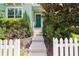 Steps leading to teal front door, surrounded by landscaping and white fence at 11125 Winthrop Lake Dr, Riverview, FL 33578