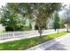 White picket fence lines the street, showing a light green house and landscaping at 11125 Winthrop Lake Dr, Riverview, FL 33578