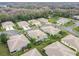 Aerial view of a community with houses, landscaping, and palm trees at 11447 Golf Round Dr, New Port Richey, FL 34654