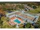 Aerial view of community pool, clubhouse, and lush landscaping at 11447 Golf Round Dr, New Port Richey, FL 34654